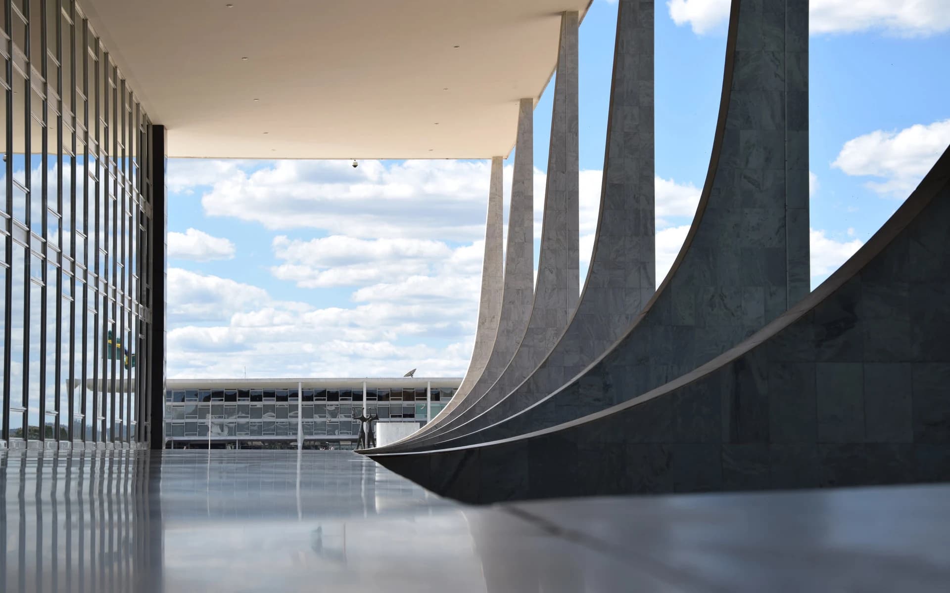 Open sky framed by the concrete columns of a modern building